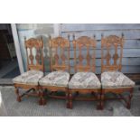 A set of four carved light oak high backed dining chairs with upholstered floral pattern seats