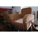 A pair of 1930s design square arm rattan armchairs, on bun feet