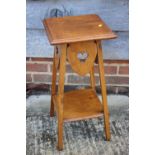 A light oak two-tier occasional table with pierced trefoil design, on square supports, 11" square