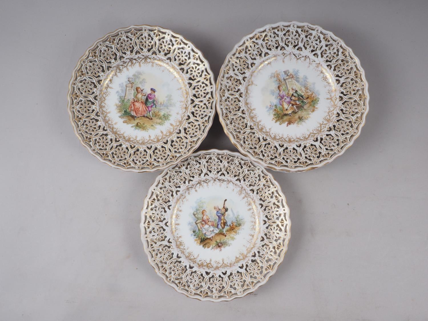 A set of twelve 19th century Dresden figure pierced decorated gilt scrollwork dessert plates (two