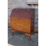 A mahogany fall front bureau with fitted interior over three drawers, on cabriole claw and ball