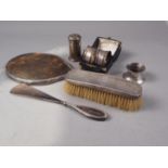 A tortoiseshell and silver mounted hand mirror, a matching shoe horn, a silver backed brush, a