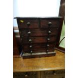 A polished as mahogany miniature chest of two short and four long drawers with knob handles, on