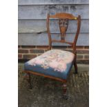 An Edwardian rosewood and inlaid splat back nursing chair with floral needlepoint seat, on turned