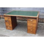 A 1920s oak desk, fitted eight drawers and green leatherette top, 58" wide x 36" deep x 29 1/2" high