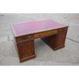 A partners early 20th century mahogany double pedestal desk with red leatherette top, fitted two