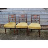 A set of three 19th century carved mahogany bar back dining chairs with stuffed over seats, on