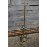 An early 20th century brass scrollwork standard lamp with reservoir and etched glass shade