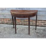 A George III mahogany and banded 'D' shaped fold-over top card table, on square taper supports,