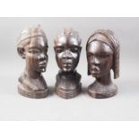 Three mid 20th century Nigerian carved ebony heads, 11" high