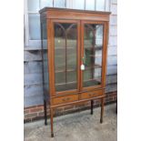 An Edwardian walnut banded and line inlaid display cabinet with astragal glazed doors enclosed two