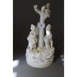 A late 18th century French bisque porcelain table centre, figures round a tree, on circular base,