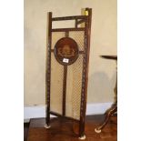 An Edwardian polished as walnut and decorated two-fold fire screen panels, 11" wide