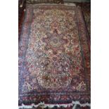 A Kashan type rug with central medallion and all-over floral design on a cream ground, in shades