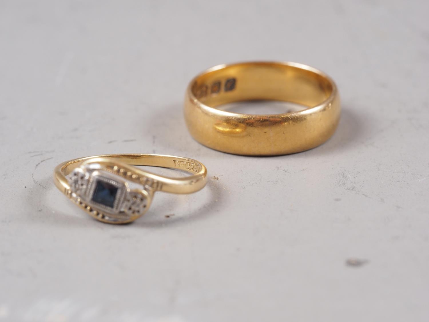 An 18ct gold, sapphire and diamond crossover ring, size J/K, 1.8g, and a 22ct gold wedding band,