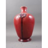 A Moorcroft pottery vase, decorated three roundels on a sang de boeuf glaze, 10" high (restoration
