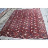 An antique Bokhara carpet of traditional design with forty-eight octagonal guls on a plum ground,