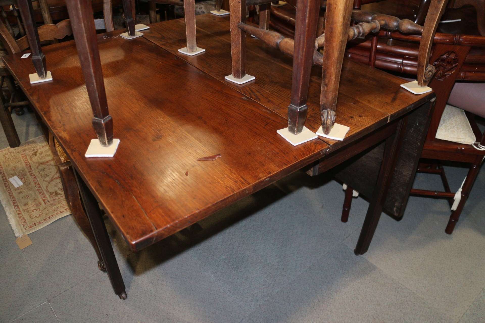 A Georgian oak drop leaf dining table, on moulded chamfered supports with brass castors, 40" wide - Image 2 of 2