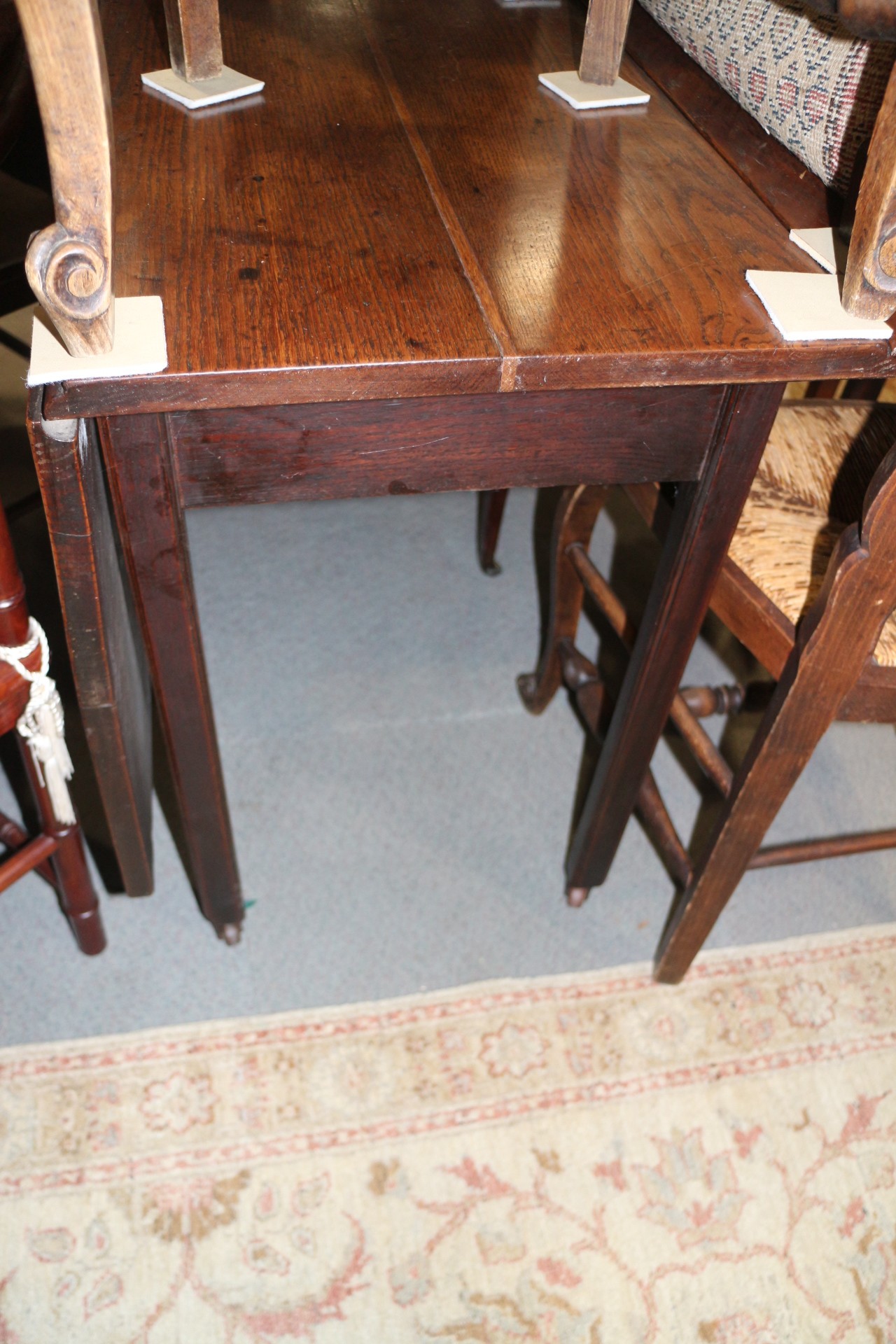 A Georgian oak drop leaf dining table, on moulded chamfered supports with brass castors, 40" wide
