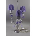 A contemporary three-light table lamp with clear and purple glass spear drops, and a Veritas