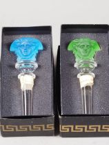 Two Rosenthal for Versace bottle stoppers, formed as the bust of Medusa, one green and one blue
