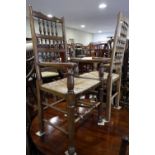 A set of six oak spindle back dining chairs with rush envelope seats, on turned and stretchered