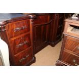 A mahogany serpentine front desk with tooled lined top, fitted seven drawers with ribbon handles and