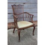 A late 19th century mahogany shaped vertical rail back open armchair with padded seat, on cabriole