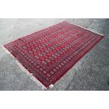 A Bokhara rug of traditional design with eighty-four guls on a red ground, 98" x 63" approx