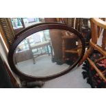 An oak oval framed wall mirror with bevelled plate, 31" x 22"