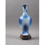 A Chinese blue spray glazed baluster vase, 9 1/2" high, on hardwood shaped scrolled stand