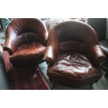 A pair of Art Deco design dark tan leather tub-shape armchairs with loose seat cushions, on turned