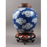 A 19th century Chinese blue and white prunus decorated ginger jar with carved hardwood cover and