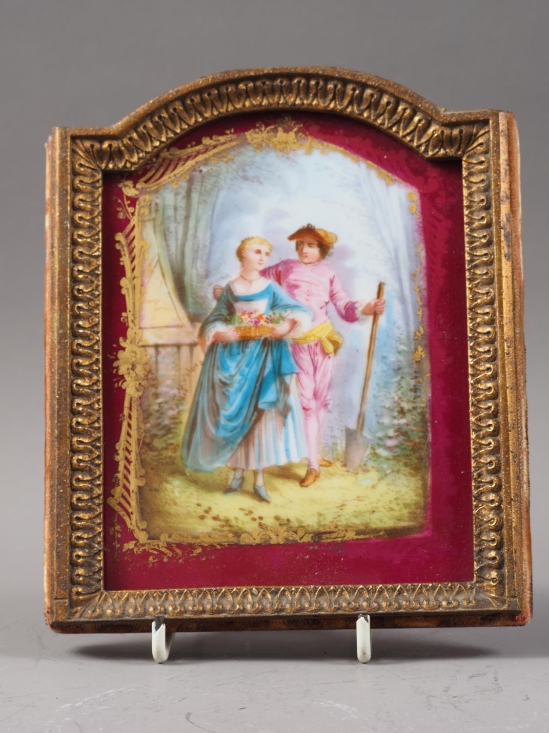 An early 19th century porcelain plaque with gardener figures, in gilt frame, 6 3/4" high