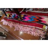 A Mexican hand-woven throw, decorated bands of vibrant colours