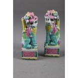 A pair of Chinese polychrome decorated Dogs of Fo, on square bases, 9" high (damages)