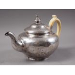 A Victorian silver teapot with engraved scrolled and coat of arms decoration and a matching milk