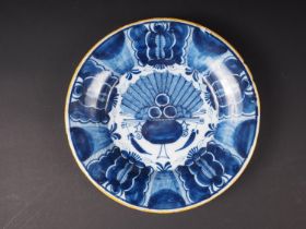 An 18th century blue and white delft dish with central urn decoration, 9" dia
