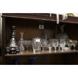 A clear glass toddy ladle, two decanters, pedestal glasses and other glassware