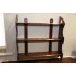 A late 19th century mahogany three-tier open wall shelf with Gothic pierced side panels, 22" wide