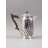 A silver hot water jug with half spiral fluted decoration and ebonised handle, 14.4oz troy approx