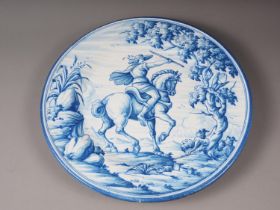 A faience charger with blue and white horse and rider decoration, 16" dia