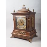 An American mantel clock with brass applied decoration and finials, silvered dial and Roman