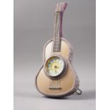 An easel clock, formed as an acoustic guitar with cream enamel dial and Arabic numerals