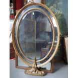 A 19th century oval carved giltwood framed wall mirror with sectional plate, 37" x 25" overall