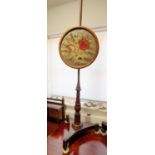 A 19th century rosewood and mahogany pole screen with floral embroidered panel, on gilt mounted