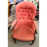 A 19th century rosewood framed scroll arm chair, upholstered in a pink velour, on turned and