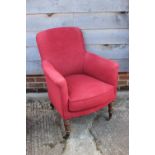 An oak framed armchair, upholstered in a red fabric, on turned supports