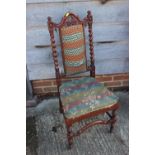 A late 19th century carved oak side chair of 17th century design with padded seat and back, on