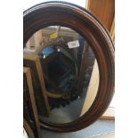 A polished as walnut oval framed wall mirror, plate 26" x 16"